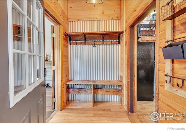 mudroom with wood walls and wood finished floors