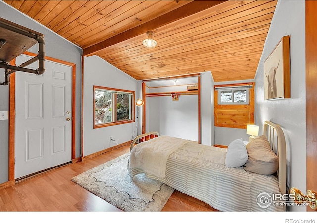 bedroom with vaulted ceiling with beams, wood ceiling, a closet, and light wood-style flooring