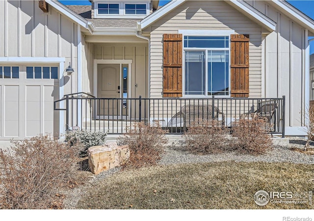 property entrance featuring a shingled roof, board and batten siding, and an attached garage