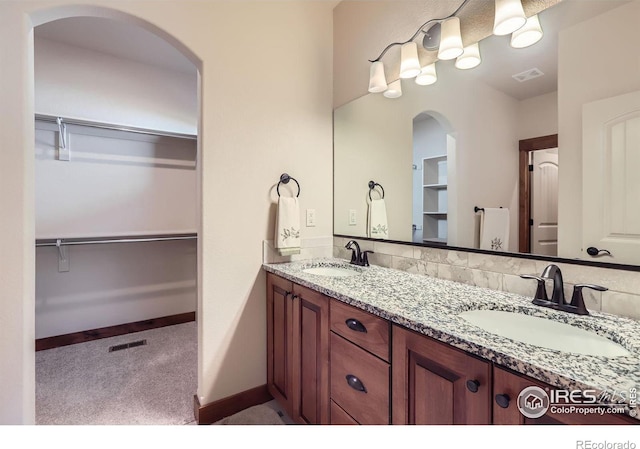 full bath featuring visible vents, a sink, and double vanity