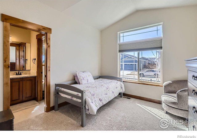 bedroom with light colored carpet, a sink, visible vents, baseboards, and vaulted ceiling