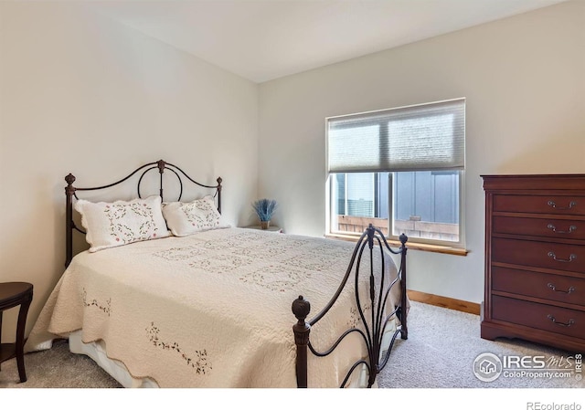 bedroom featuring light colored carpet and baseboards