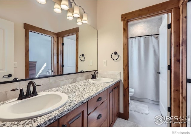 full bath featuring curtained shower, a sink, toilet, and double vanity