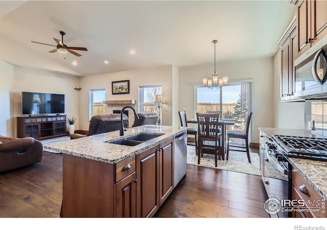 kitchen featuring open floor plan, appliances with stainless steel finishes, a sink, and dark wood finished floors