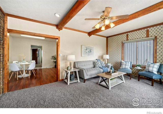 living room featuring dark colored carpet, beam ceiling, baseboards, and wallpapered walls