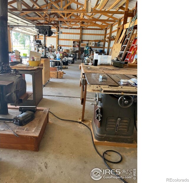 garage with a wood stove, metal wall, and a workshop area