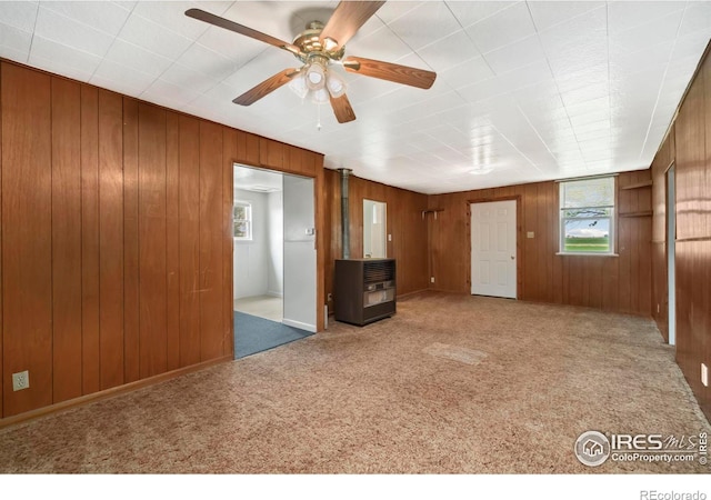 interior space with plenty of natural light, wood walls, and carpet