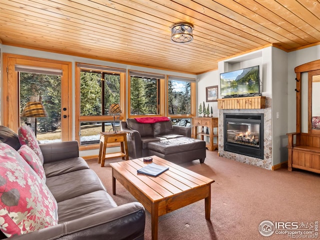 living area with wood ceiling, ornamental molding, carpet flooring, and a glass covered fireplace