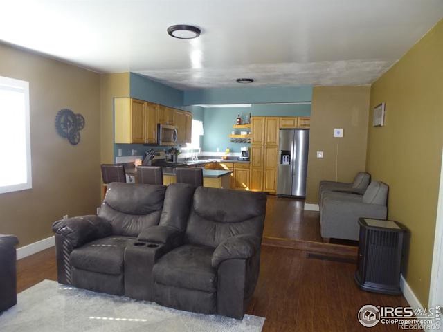 living area featuring baseboards and wood finished floors