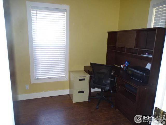 home office featuring baseboards and dark wood-type flooring