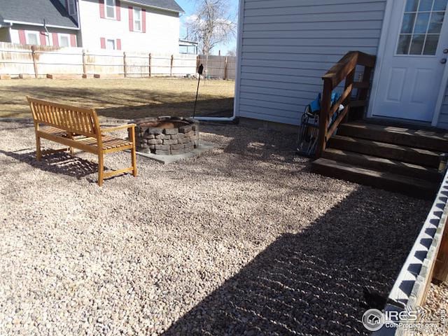 view of yard featuring an outdoor fire pit, fence, and entry steps