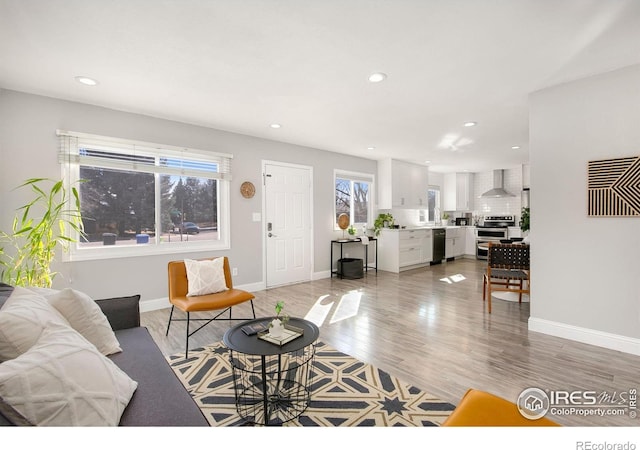 living room featuring recessed lighting, light wood-style flooring, and baseboards