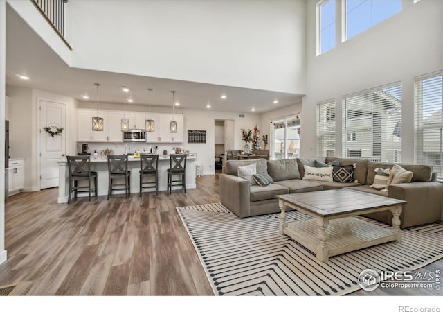 living room with plenty of natural light, wood finished floors, and recessed lighting