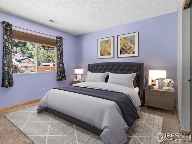 bedroom featuring baseboards, carpet, visible vents, and a textured ceiling