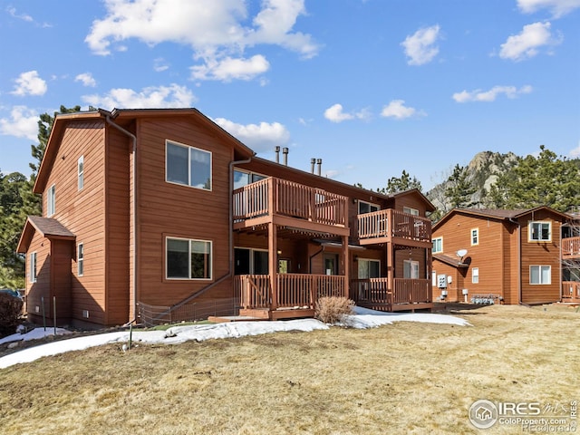 back of house featuring a deck and a yard