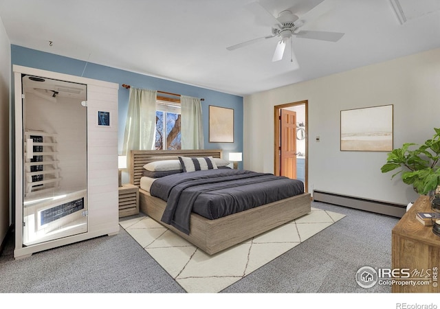 bedroom featuring ensuite bath, a baseboard heating unit, ceiling fan, and light colored carpet