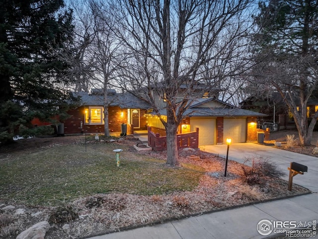 view of front of home with a garage, driveway, brick siding, and a front yard