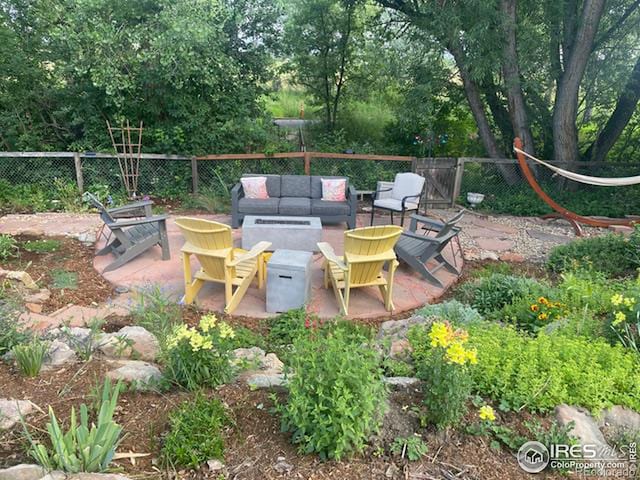 view of patio / terrace featuring an outdoor living space with a fire pit and fence