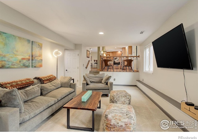 living room with recessed lighting, visible vents, baseboards, and light colored carpet