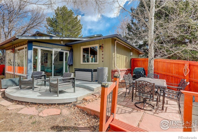 view of patio / terrace featuring outdoor dining space, a sunroom, and fence