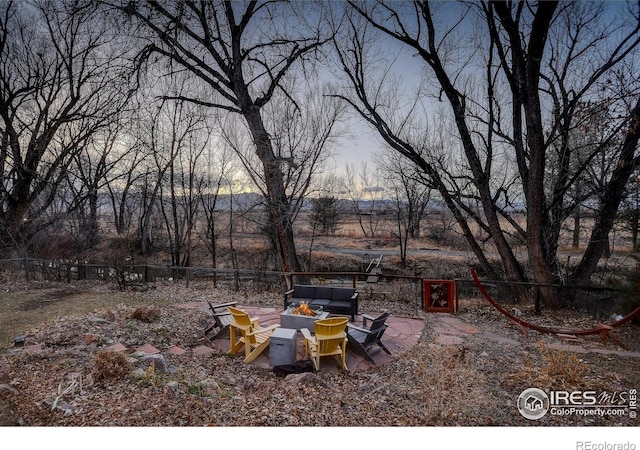 view of yard featuring a patio area, an outdoor fire pit, and fence