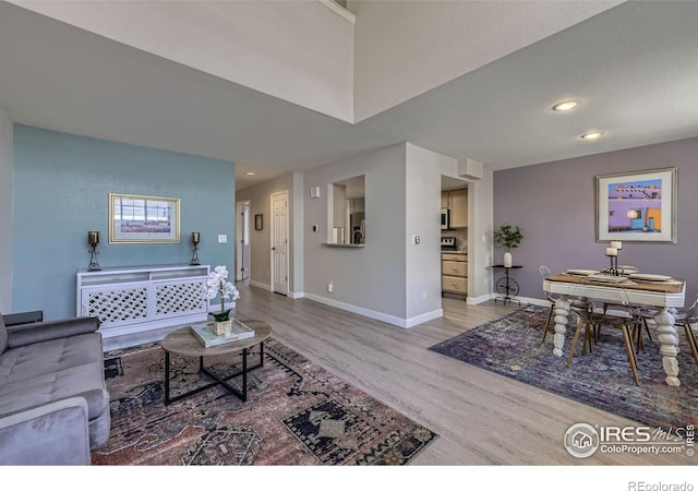 living area with recessed lighting, baseboards, and wood finished floors