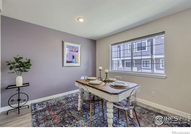 dining space featuring wood finished floors and baseboards