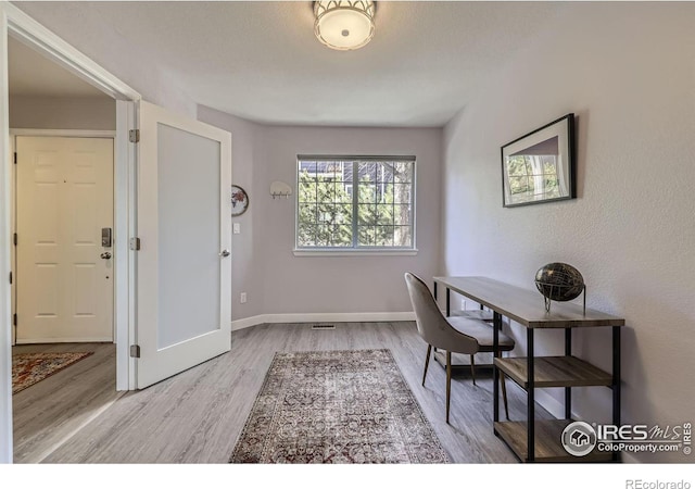 home office with visible vents, baseboards, and wood finished floors