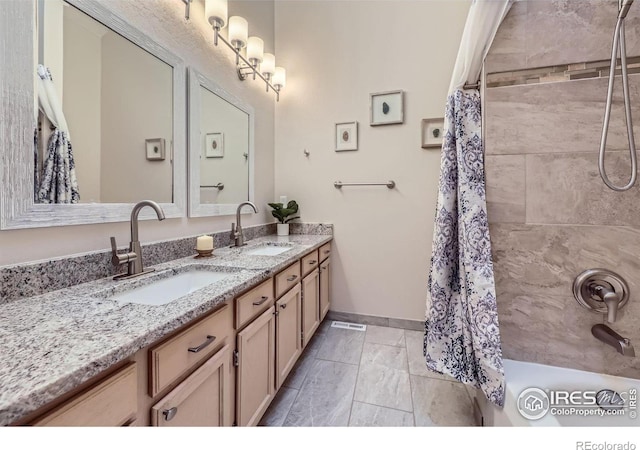 full bathroom featuring shower / bath combination with curtain, a sink, baseboards, and double vanity