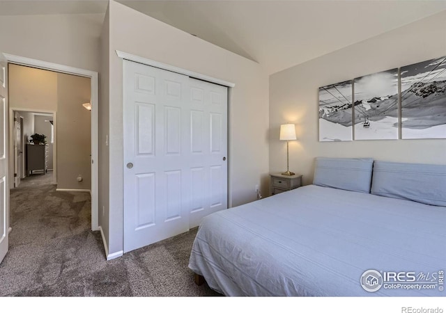 bedroom featuring lofted ceiling, carpet floors, a closet, and baseboards