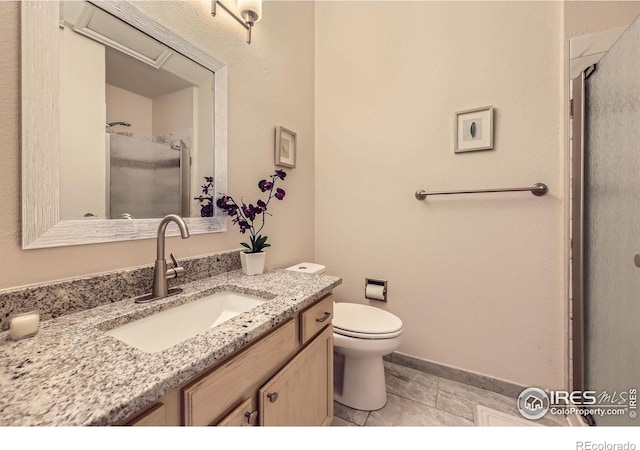 bathroom featuring a stall shower, vanity, and toilet