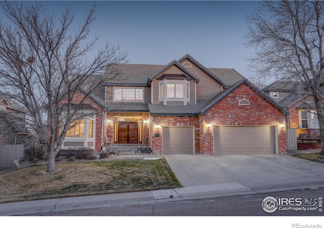 view of front of home with brick siding, concrete driveway, an attached garage, a front yard, and a tiled roof