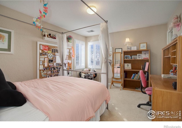 carpeted bedroom featuring visible vents