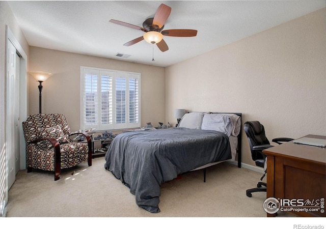 bedroom with a ceiling fan, light colored carpet, and visible vents