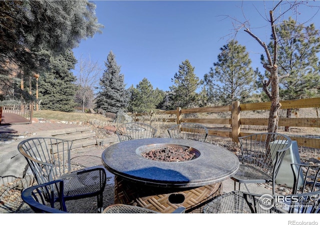 view of patio featuring a fire pit and fence