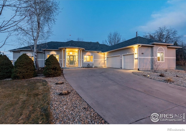 single story home featuring an attached garage, driveway, roof with shingles, and stucco siding