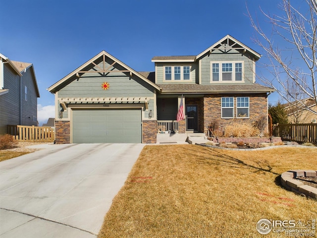 craftsman-style home featuring a porch, concrete driveway, a front yard, fence, and a garage