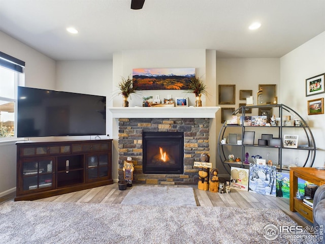 living area featuring recessed lighting, a fireplace, and wood finished floors