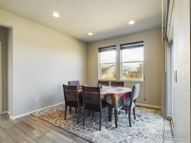 dining space featuring recessed lighting, wood-type flooring, and baseboards