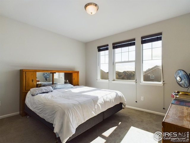 bedroom featuring dark colored carpet and baseboards