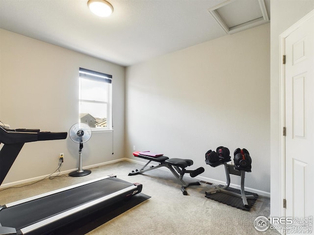 exercise area featuring carpet floors, attic access, and baseboards