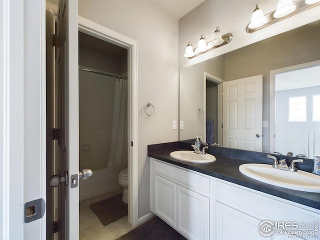 bathroom with toilet, double vanity, a sink, and shower / tub combo with curtain