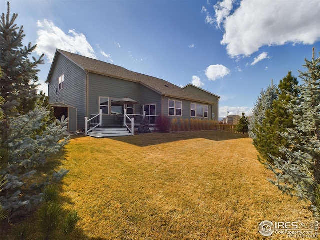 rear view of house featuring a deck and a lawn