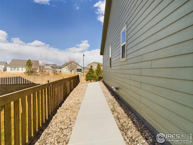 view of side of home featuring a residential view and fence