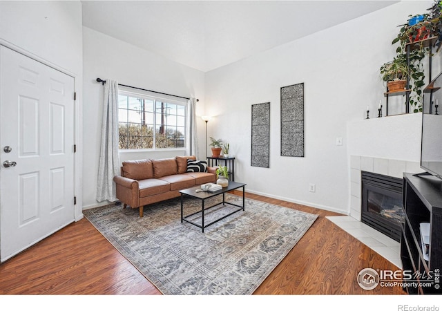 living area with light wood finished floors, a fireplace, and baseboards