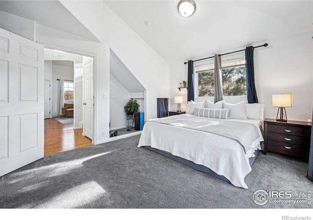 bedroom with carpet, vaulted ceiling, and baseboards