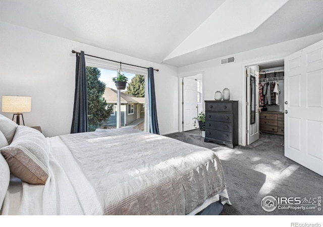 bedroom featuring visible vents, lofted ceiling, access to outside, a walk in closet, and dark carpet