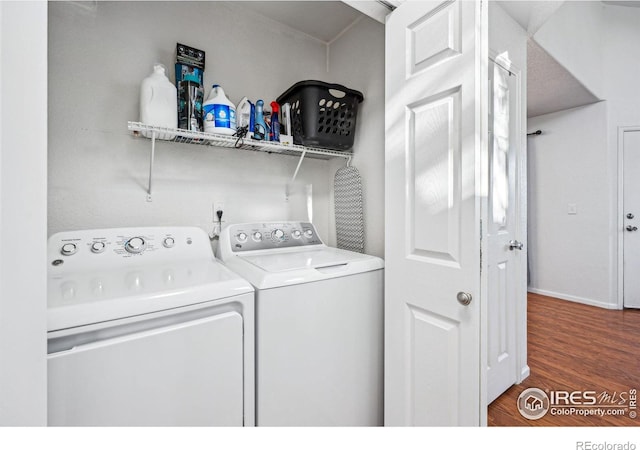 washroom with laundry area, separate washer and dryer, and dark wood-type flooring