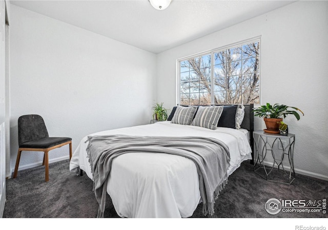 bedroom featuring dark colored carpet and baseboards