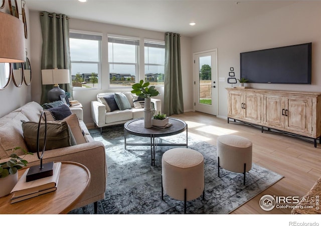 living room featuring light wood-type flooring, baseboards, and recessed lighting